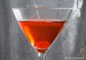 Manhattan Cocktail vor silberfarbigem Hintergrund