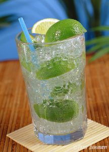 Caipirinha Cocktail vor tropischem Hintergrund