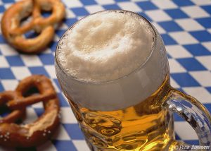 ein Maßkrug mit bayrischem Bier, daneben zwei Brezen